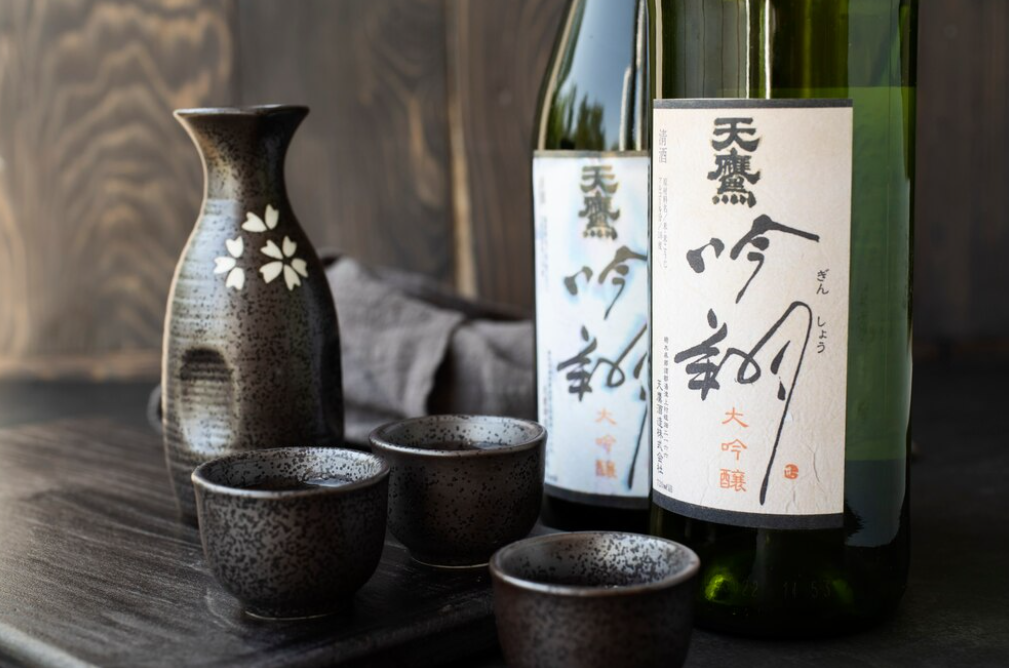 Japanese sake set with bottles and ceramic cups on a wooden table