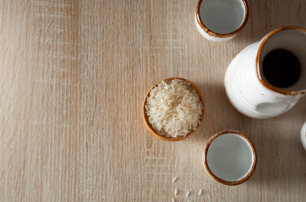 Bowl of rice with sake set on a wooden table